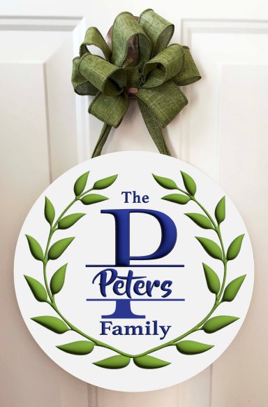 Round sign with green laurel and "The Peters Family" in blue text, adorned with a green bow.