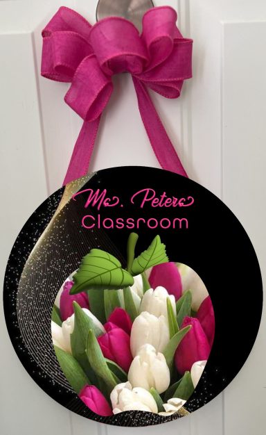 A sign for "Ms Peter's Classroom" decorated with pink and white tulips.