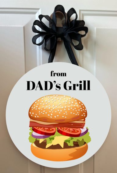Sign with a burger graphic and text "from DAD's Grill," decorated with a black bow.