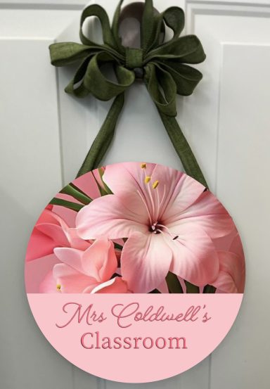 Round sign with pink flowers and a green ribbon, labeled "Mrs. Caldwell's Classroom."